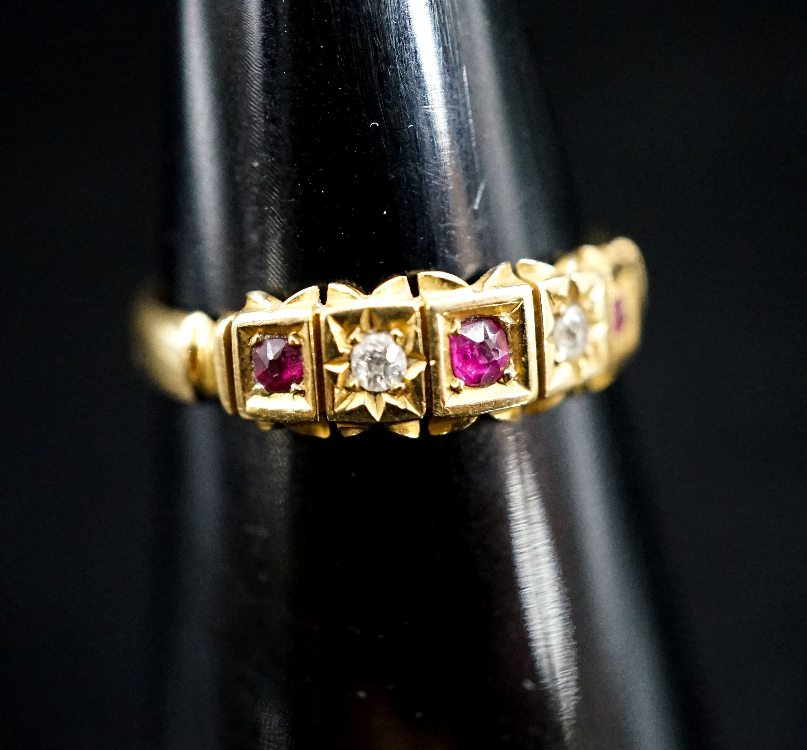 A late Victorian 18ct gold, ruby and diamond chip set half hoop ring, size O, gross 2.5 grams.